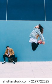 Young Happy Couple Dancing On The Street With A Vintage Radio Cassette Stereo 
