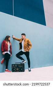 Young Happy Couple Dancing On The Street With A Vintage Radio Cassette Stereo 
