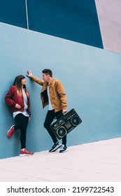 Young Happy Couple Dancing On The Street With A Vintage Radio Cassette Stereo 
