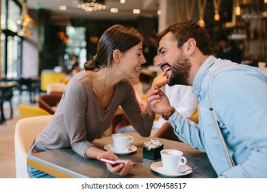 Young happy couple at a date in a coffee shop