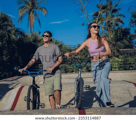 Young happy couple enjoy BMX riding at the skatepark