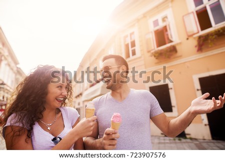 Young happy couple enjoying ice cream and summer in the city.
