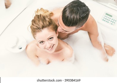 Young happy couple enjoying jot bath in the jacuzzi