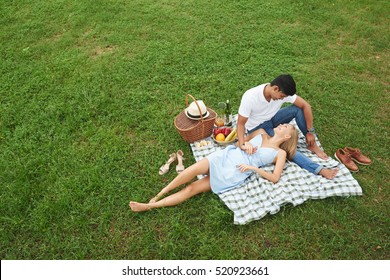 Young Happy Couple Enjoying Picnic In Park