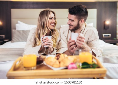 Young Happy Couple Having Breakfast In Luxury Hotel Room. 