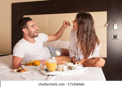 Young Happy Couple Having Breakfast In Luxury Hotel Room.