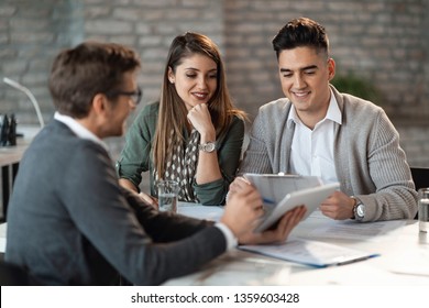 Young Happy Couple Having Consultations With Bank Manager On A Meeting In The Office.