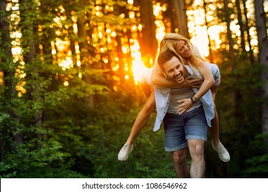 Young happy couple having fun in the forest at sunset. - Powered by Shutterstock