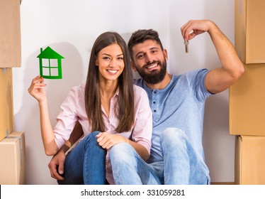 Young happy couple holding keys to new home, moving to a new home
