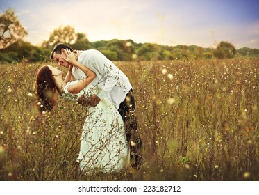 Young Happy Couple Hugging On The Field, On The Sunset 