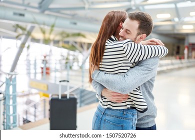 Young Happy Couple Hugs Each Other While Reunion After The Trip At The Airport