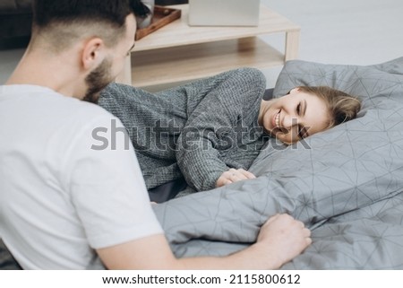Young happy couple in love having fun together in bedroom at home