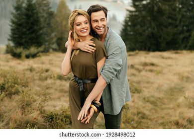 Young Happy Couple In Love Hugging Smiling And Having Fun In The Mountains. High Quality Photo