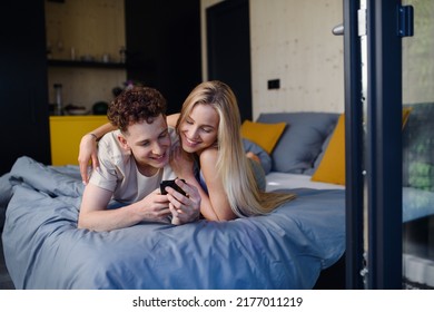 Young Happy Couple In Love Lying In Bed In Morning In Their New Home In Tiny House,sustainable Living Concept.