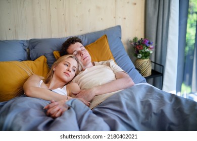 Young Happy Couple In Love Lying In Bed In Morning In Their New Home In Tiny House, Sustainable Living Concept.