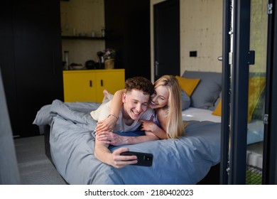 Young Happy Couple In Love Lying In Bed In Morning In Their New Home In Tiny House,sustainable Living Concept.