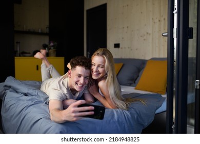 Young Happy Couple In Love Lying In Bed In Morning In Their New Home In Tiny House,sustainable Living Concept.