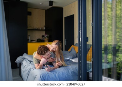 Young Happy Couple In Love Lying In Bed In Morning In Their New Home In Tiny House,sustainable Living Concept.