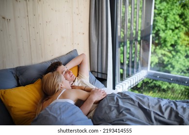 Young Happy Couple In Love Lying In Bed In Morning In Their New Home In Tiny House,sustainable Living Concept.