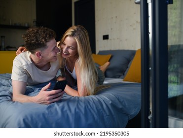 Young Happy Couple In Love Lying In Bed In Morning In Their New Home In Tiny House,sustainable Living Concept.