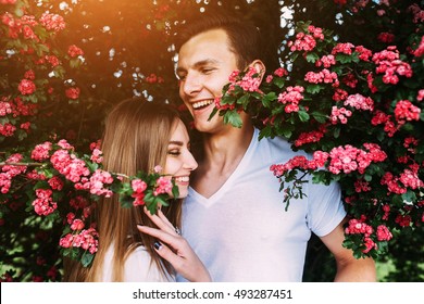 Young Happy Couple In Love Outdoors. Loving Man And Woman On A Walk In A Spring Blooming Park