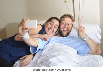 young happy couple in love taking selfie photo at hospital room with man ill lying in bed at clinic holding mobile phone shooting himself together with wife or girlfriend in positive thinking concept - Powered by Shutterstock