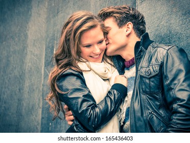 Young happy couple of lovers at beginning of love story - Handsome man whispers soft kisses in beautiful woman ear - Fall fashion concept with boyfriend and girlfriend on a cold vintage filtered look
 - Powered by Shutterstock