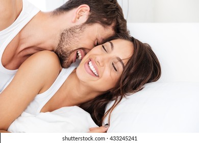 Young Happy Couple Lying Together In Bed