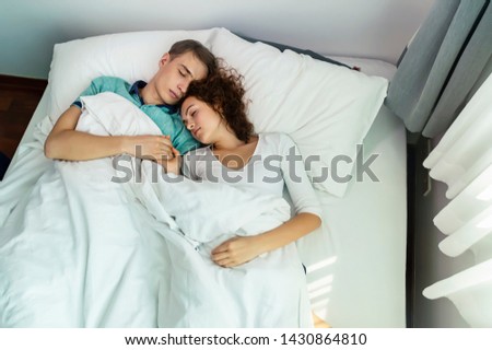 Similar – Mother reading book to her sons in the bed