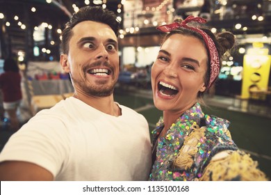 Young  and happy couple is making funny faces at evening street  - Powered by Shutterstock