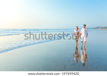 Young happy couple on a sea beach at sunset. India, state Goa