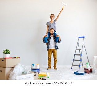 Young Happy Couple Is Repairing And Painting The Wall At Home
