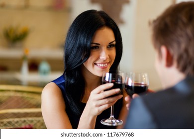 Young Happy Couple Romantic Date Drink Glass Of Red Wine At Restaurant, Celebrating Valentine Day