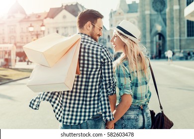 Young Happy Couple With Shopping Bags In The City.