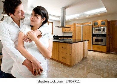 Young Happy Couple Smiling At Kitchen Of New House