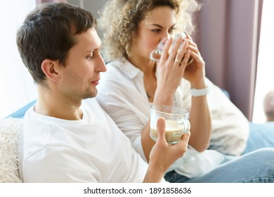 Young happy couple spending time together and drinking coffee at home - Shutterstock ID 1891858636