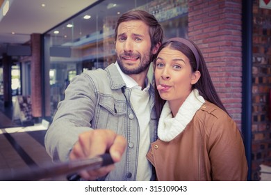 Young Happy Couple Taking A Selfie While Making Weird Faces In Front Of A Store