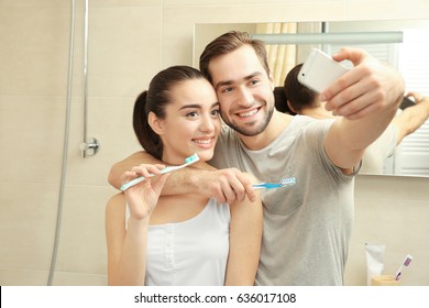 Young Happy Couple Taking Selfie While Brushing Teeth In Bathroom