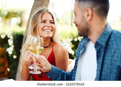 Young happy couple toasts with wine during dinner at a restaurant during a summer day - Shutterstock ID 2165578165
