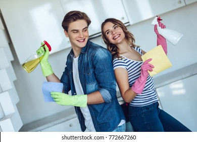 Young Happy Couple Is Washing Kitchen While Doing Cleaning At Home.