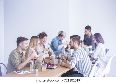 Young Happy Coworkers Talking And Eating Lunch Together