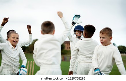 Young happy cricketers cheering on the field - Powered by Shutterstock