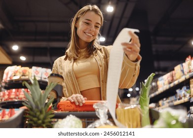 Young happy customer woman wears casual clothes read check bill shopping at supermaket store grocery shop buying with trolley cart choose products in hypermarket. Purchasing food gastronomy concept - Powered by Shutterstock