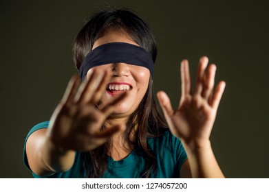 Young Happy And Cute Blindfolded Asian Korean Teenager Girl Excited Playing Dangerous Internet Viral Challenge Isolated On Dark Background Under Edgy And Dramatic Studio Light