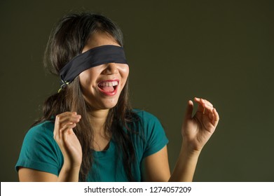 Young Happy And Cute Blindfolded Asian Korean Teenager Girl Excited Playing Dangerous Internet Viral Challenge Isolated On Dark Background Under Edgy And Dramatic Studio Light