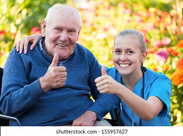Young happy doctor showing thumbs up with his elderly patient.