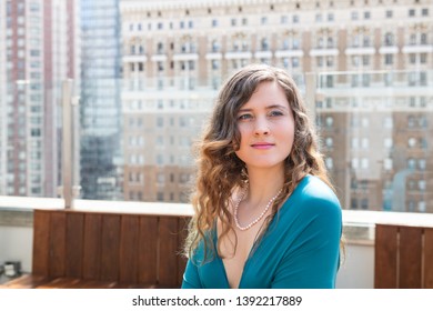 Young Happy Elegant Smiling Woman Sitting On Rooftop Restaurant Table In New York City NYC In Blue Dress At Wedding Reception