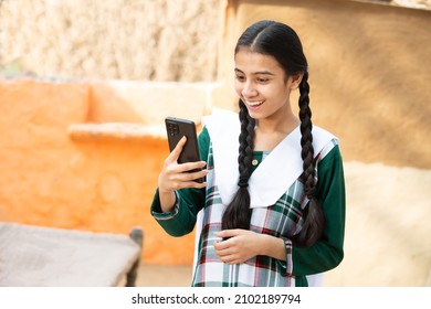 Young Happy Excited Rural Indian girl do video call on Smart phone, Cheerful braided female using digital android mobile phone or cellphone device, She is talking, skill india.