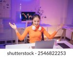 Young happy excited successful asian businesswoman raising hands celebrating success working on laptop computer at home office desk at night, business growth, financial chart on screen