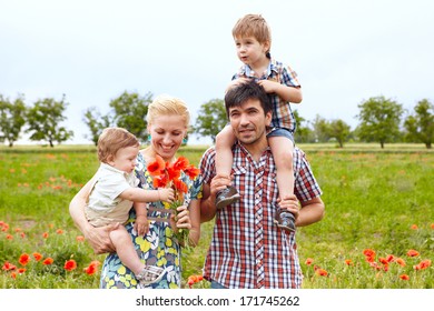 Young happy family of four having fun together outdoor.
